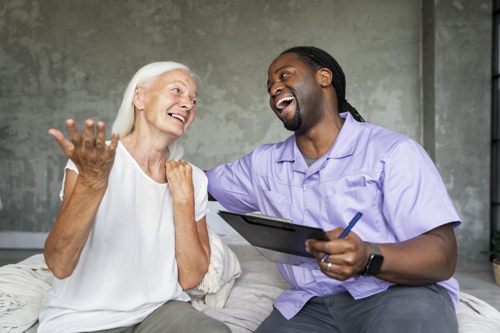 Elderly woman and consultant holding a notepad laughing with each other